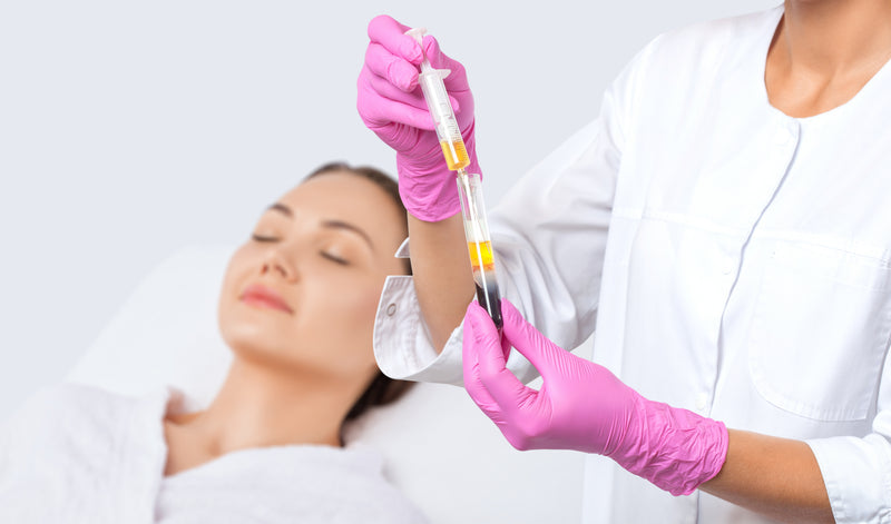 A provider preparing a PRP syringe while a client rests