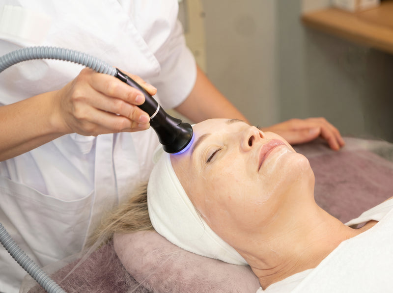 A provider using a cooling device during a facial treatment