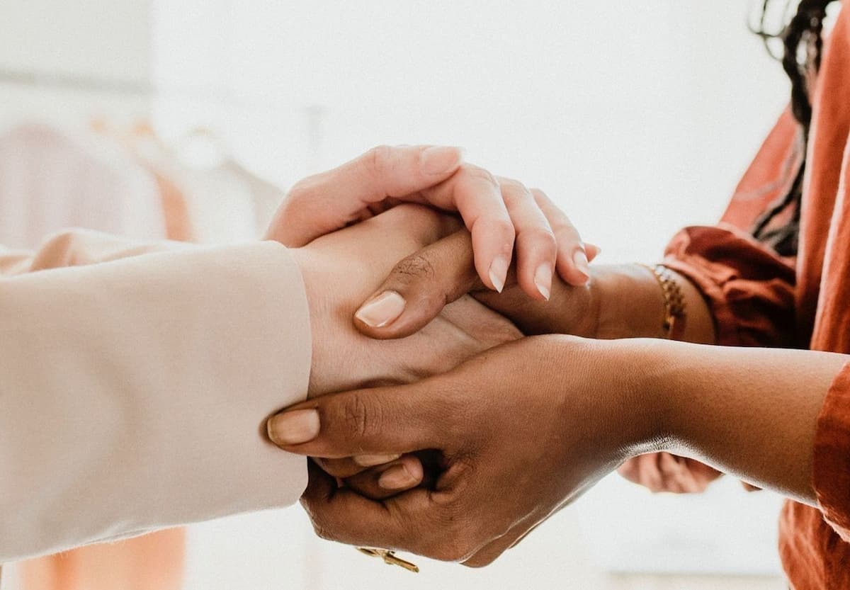 Two people holding hands in support